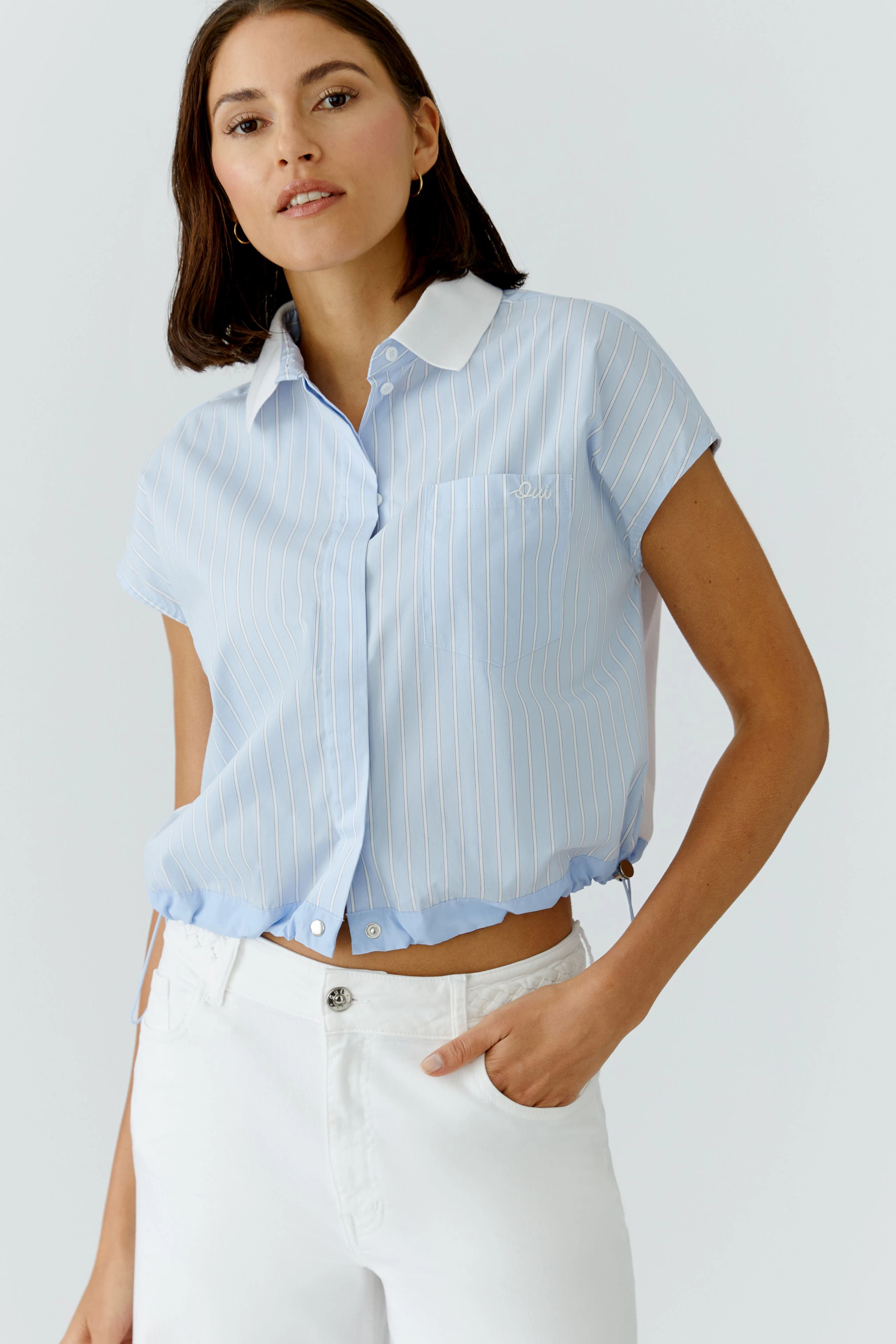 Casual women's blouse: Woman in a light blue striped blouse with a collar and short sleeves.