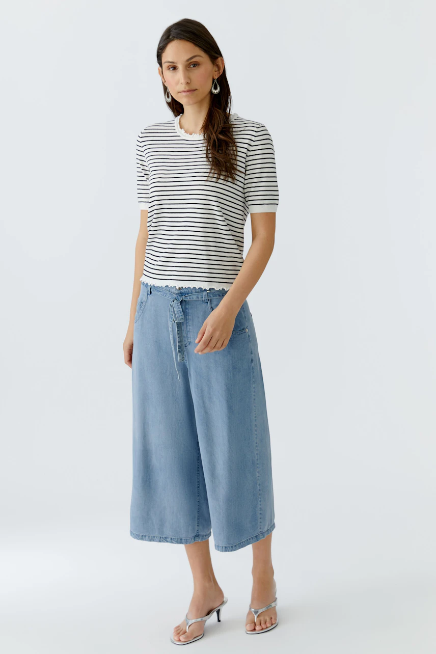 Casual women's pullover: Young woman in a striped pullover paired with light blue culottes.