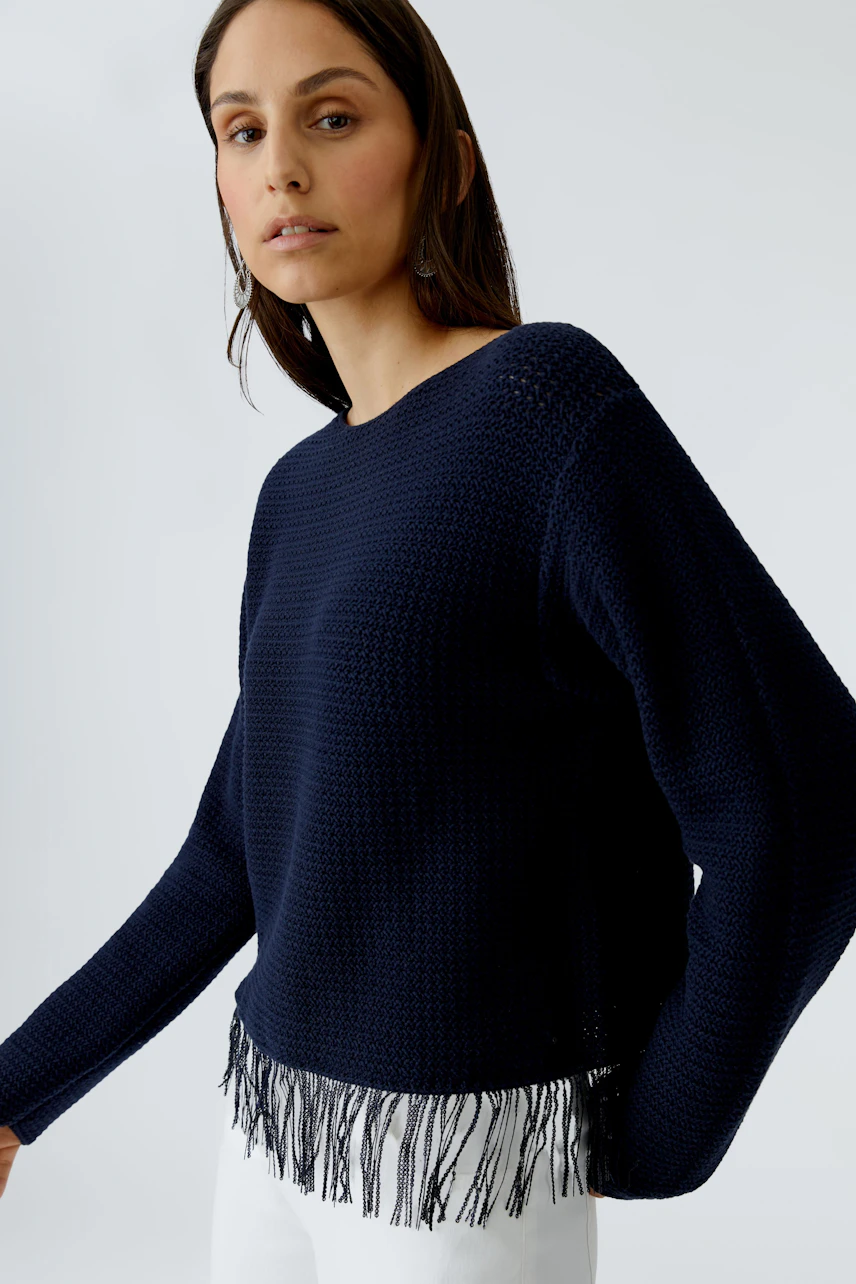 Casual women's pullover: A woman in a navy pullover with fringe detail, styled effortlessly.
