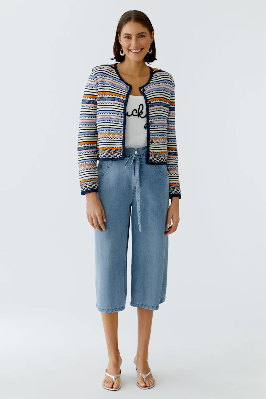 Modern women's cardigan: A woman in a colorful knitted cardigan over a casual outfit.