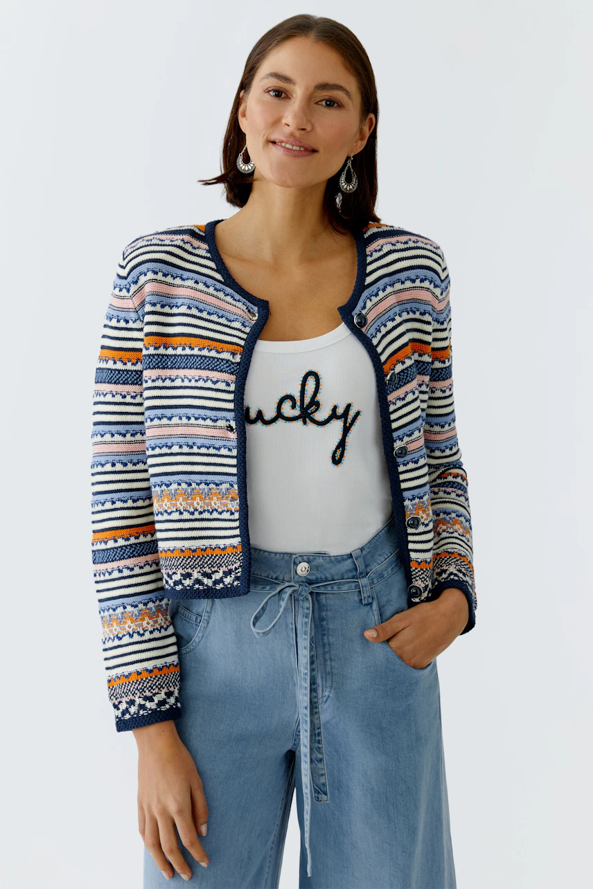 Colorful women's cardigan with a patterned design, paired with a casual top and relaxed jeans.