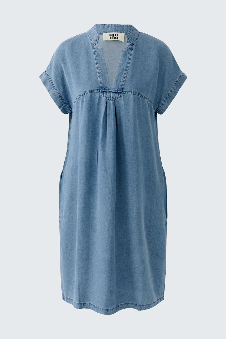 Casual denim dress: A woman in a loose-fitting blue denim dress with short sleeves and a relaxed neckline.