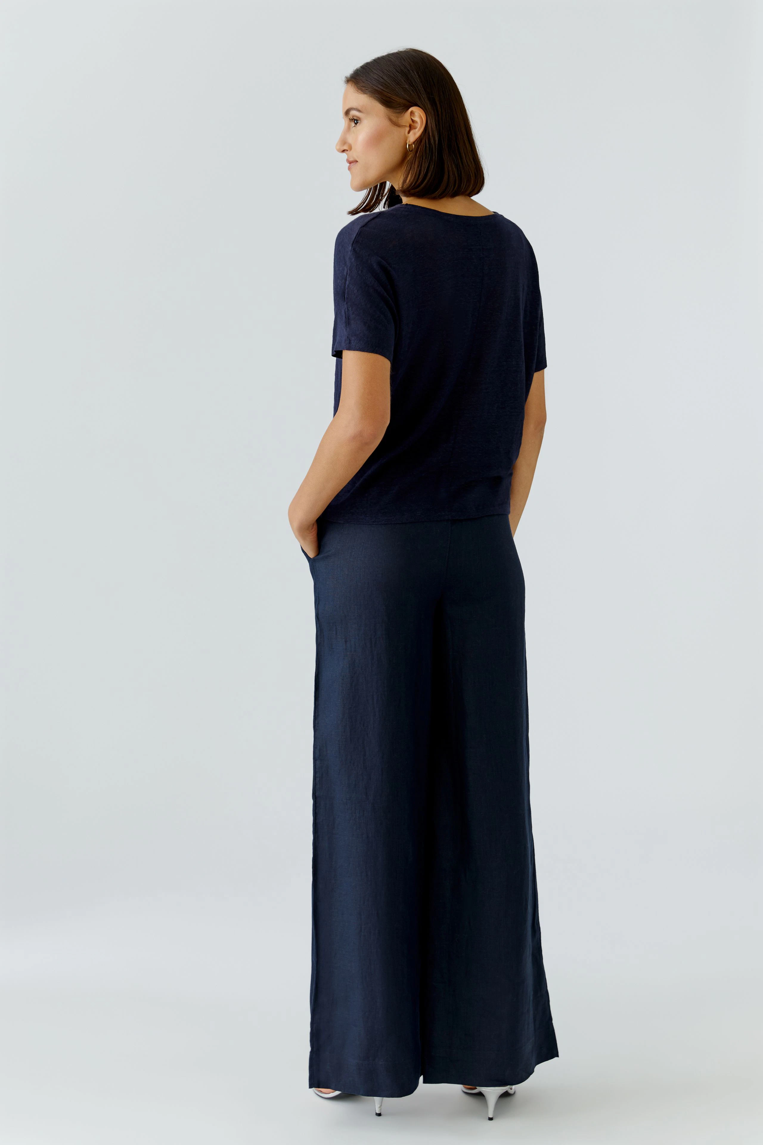 Damen-T-Shirt: Frau in dunkelblauem T-Shirt mit lässigem Schnitt und bequemen Hosen.