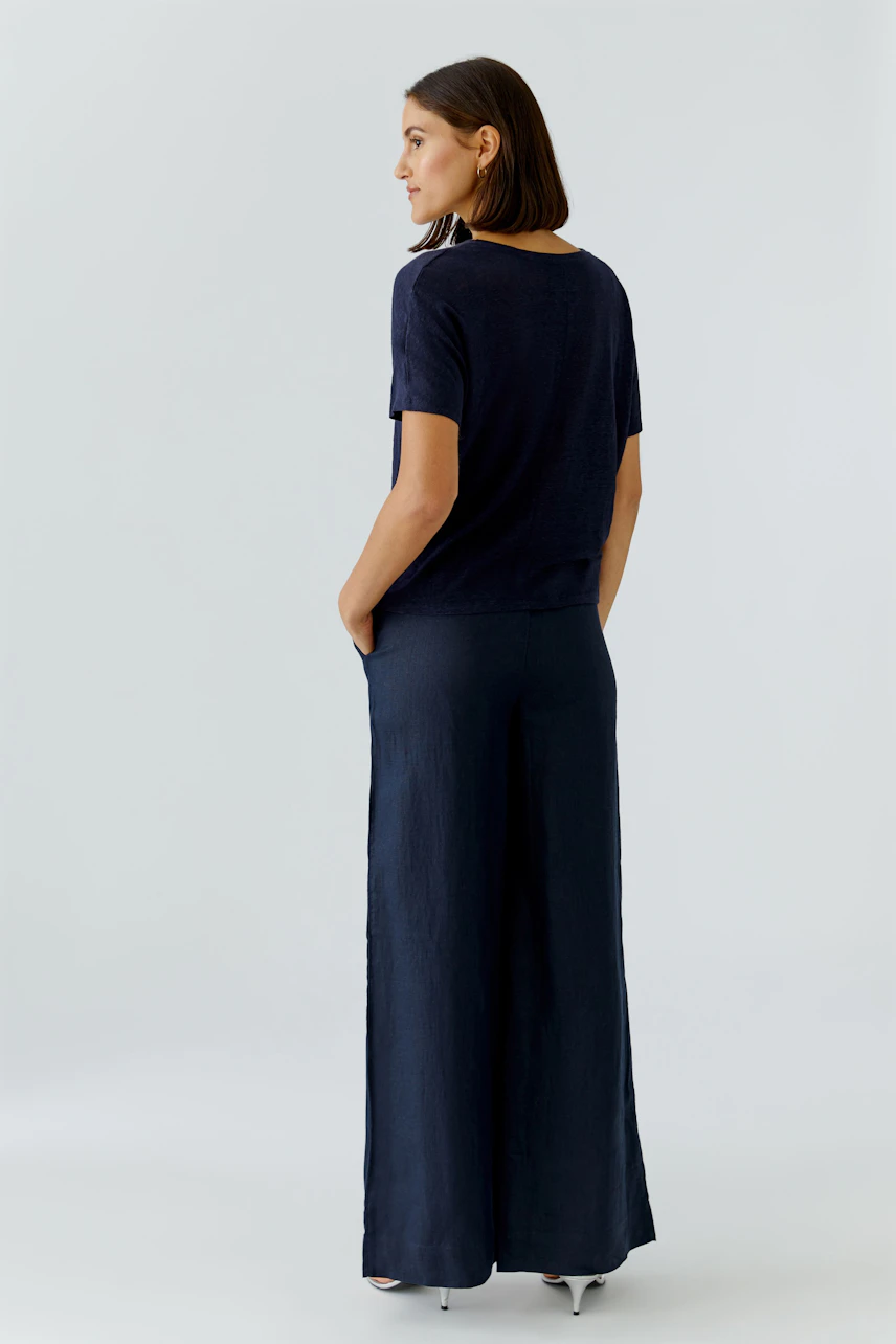 Damen-T-Shirt: Frau in dunkelblauem T-Shirt mit lässigem Schnitt und bequemen Hosen.