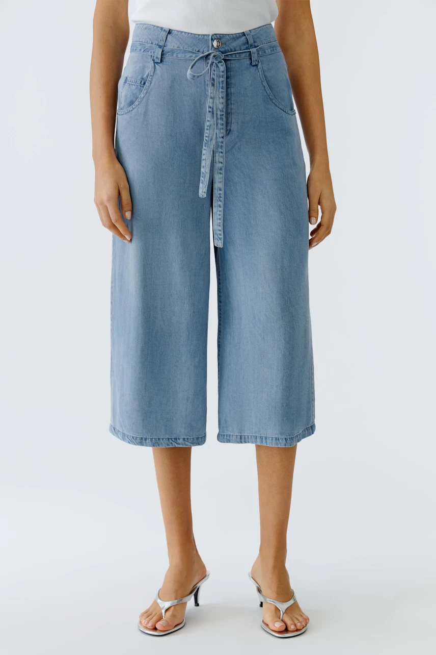 Casual women's pants: A woman in light blue wide-leg pants with a drawstring waist stands confidently.