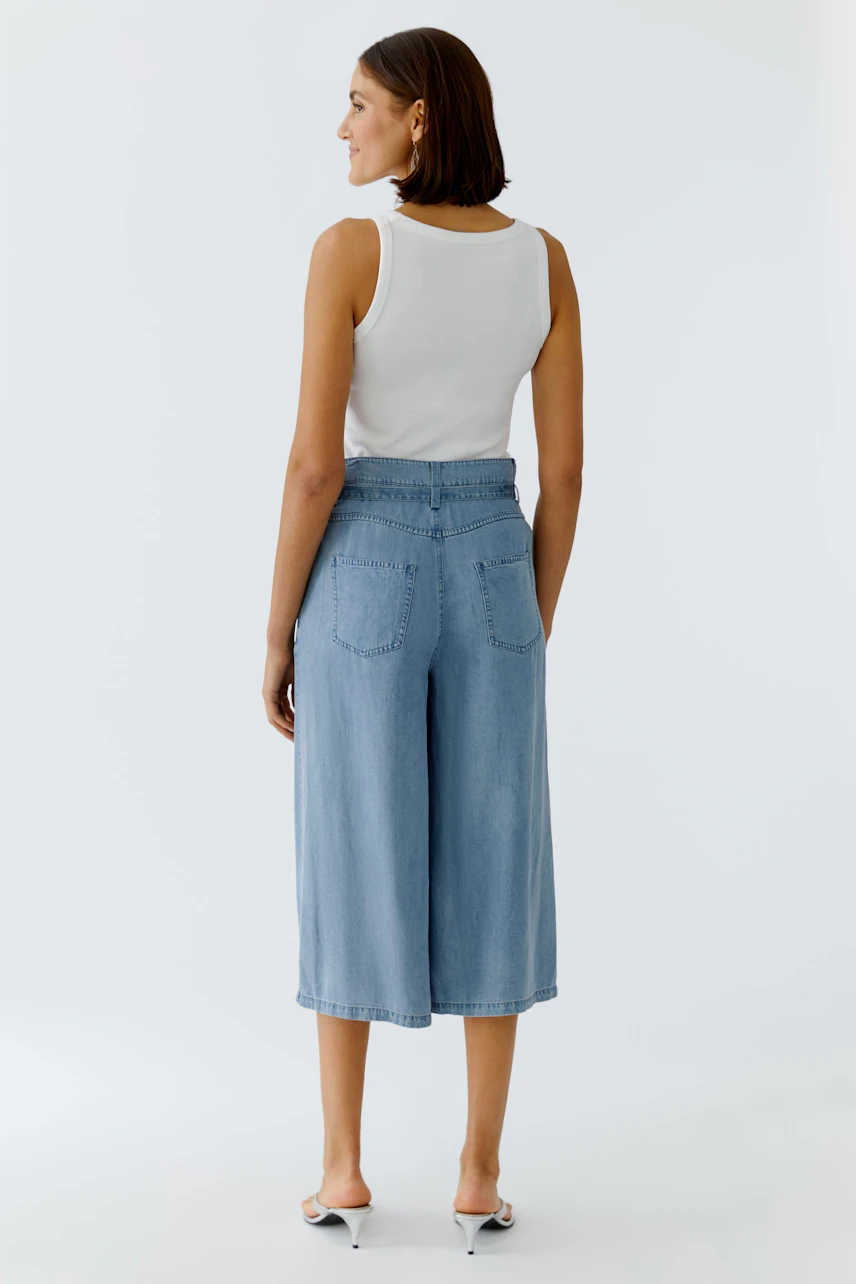 Casual women's culottes: A woman in light blue wide-leg pants with a high waist and back pockets.