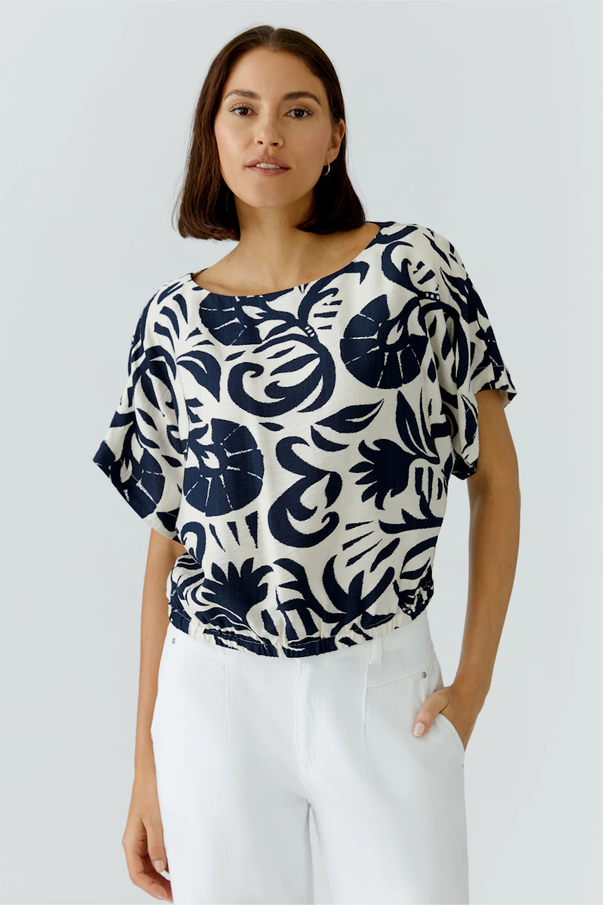 Casual women's blouse: A woman in a loose-fitting, patterned blouse with a relaxed silhouette.