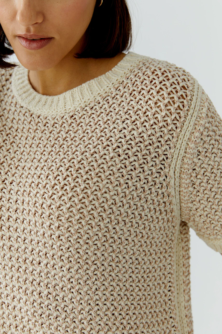 Casual women's pullover: Close-up of a woman in a light knitted pullover with a relaxed fit.