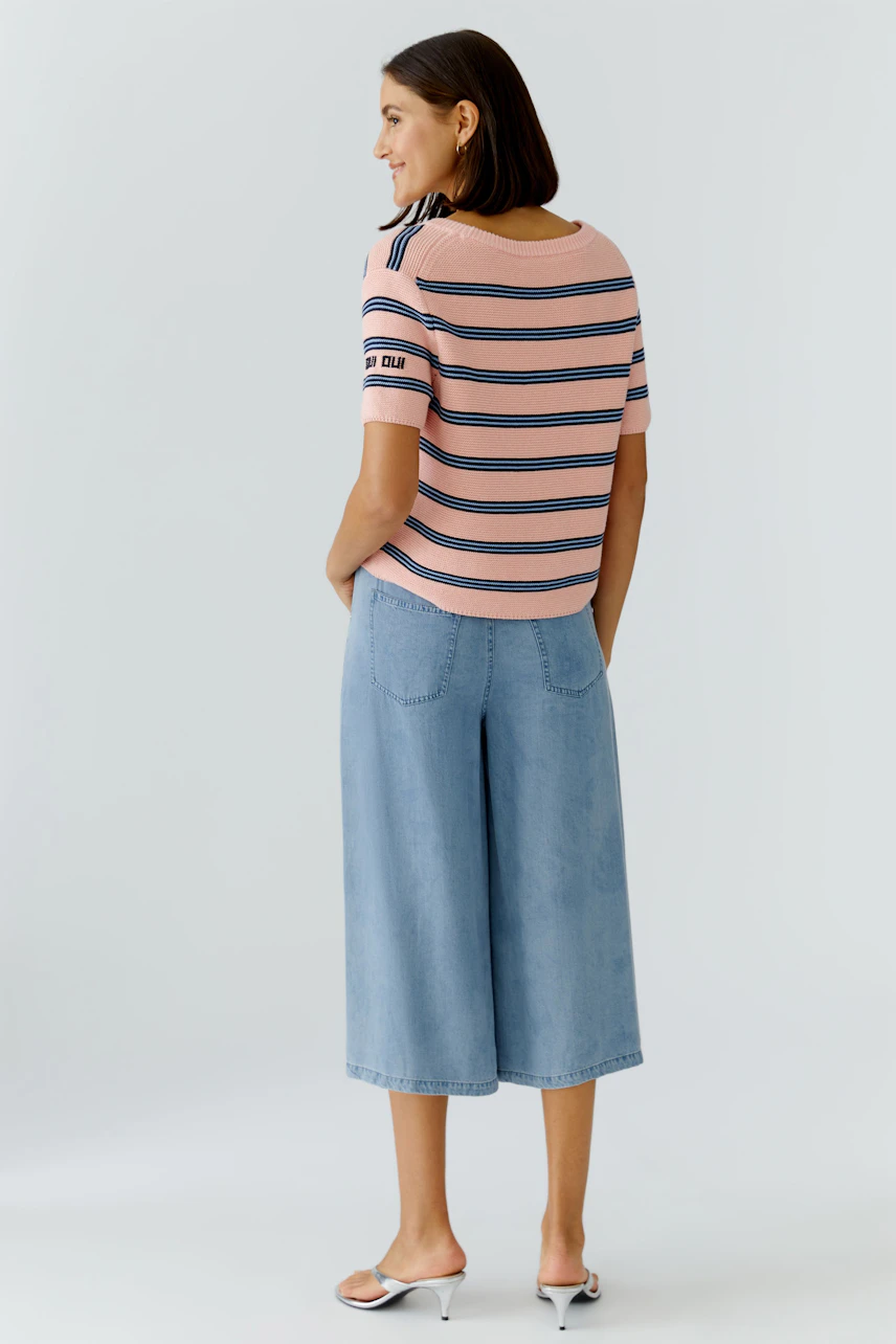 Casual women's pullover: A woman in a striped pullover with short sleeves and relaxed fit.
