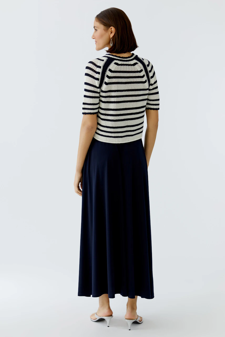 Casual women's cardigan: A woman in a striped short-sleeve cardigan paired with a long navy skirt.