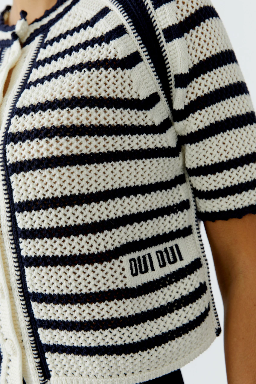 Casual women's cardigan: A woman in a striped knit cardigan with a zip and logo detail.