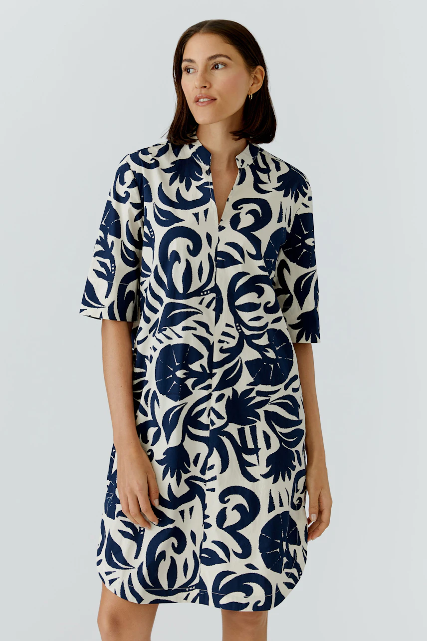 Casual dress: Woman in a navy and white patterned dress with short sleeves and a relaxed fit.
