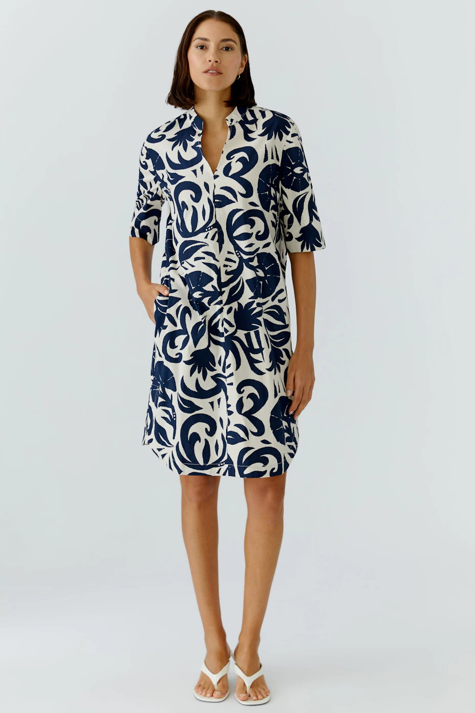 Casual women's dress: A woman in a navy and white patterned dress with short sleeves and a relaxed fit.
