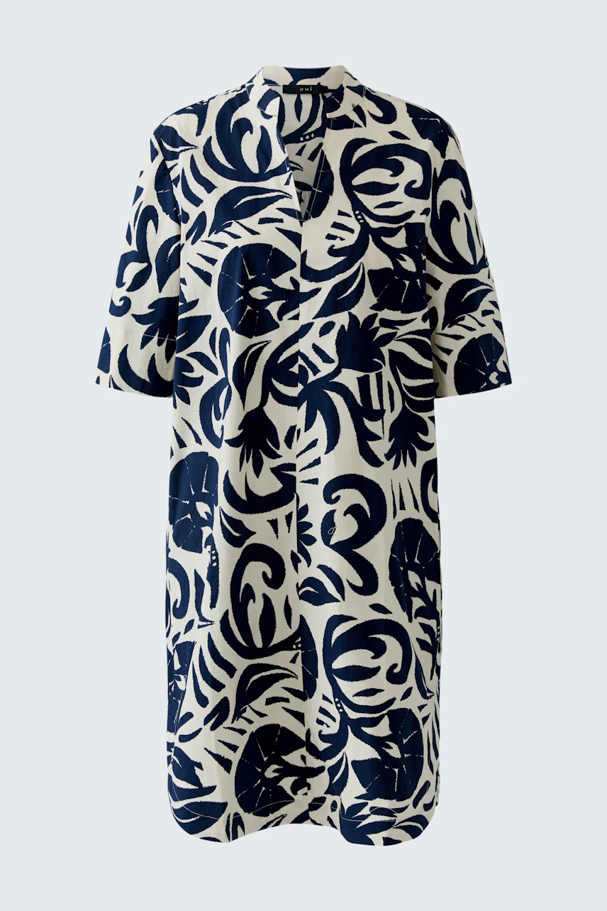 Casual women's dress: A woman in a navy and white patterned dress with short sleeves and a relaxed fit.
