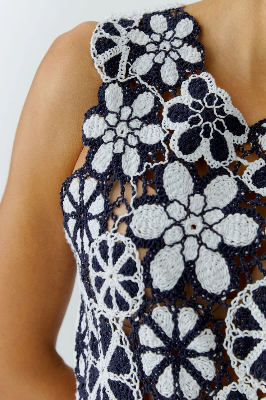 Stylish women's top: Close-up of a woman wearing a floral crochet top with navy and white patterns.