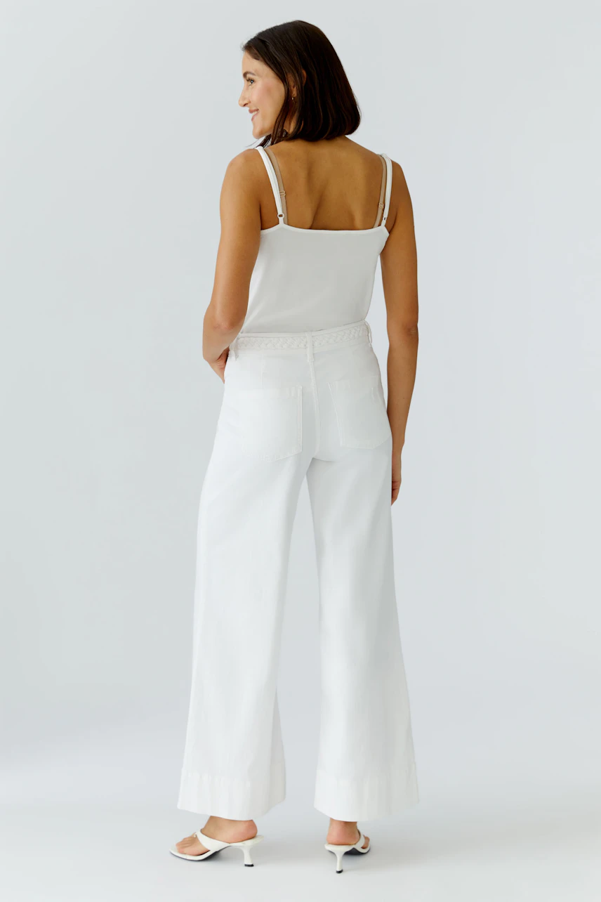 Casual wide leg jeans: Woman in white wide leg jeans with a relaxed fit, showcasing a simple design.