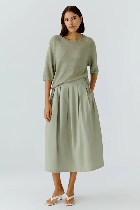 Casual A-line skirt in light green, featuring pleats and a high waist, perfect for everyday wear.
