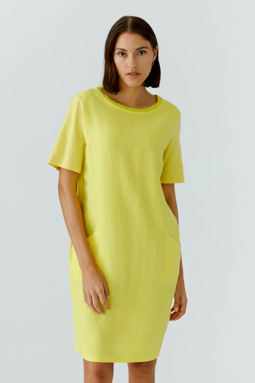 Casual hanger dress: Woman in a bright yellow dress with short sleeves and a relaxed fit.