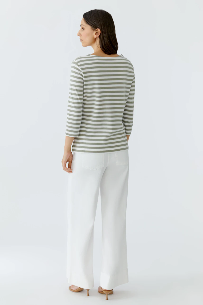 Gestreiftes Damen-T-Shirt: Frau in grauweißem Streifen-T-Shirt und weißen Hosen, Rückansicht.