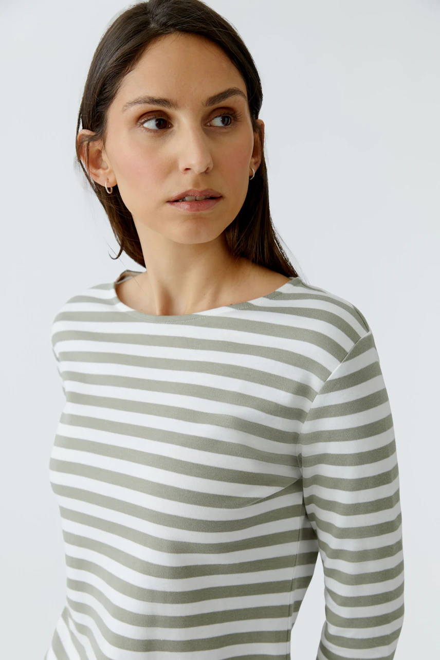 Gestreiftes Damen-T-Shirt: Frau im weiß-grünen Streifen-T-Shirt schaut zur Seite.