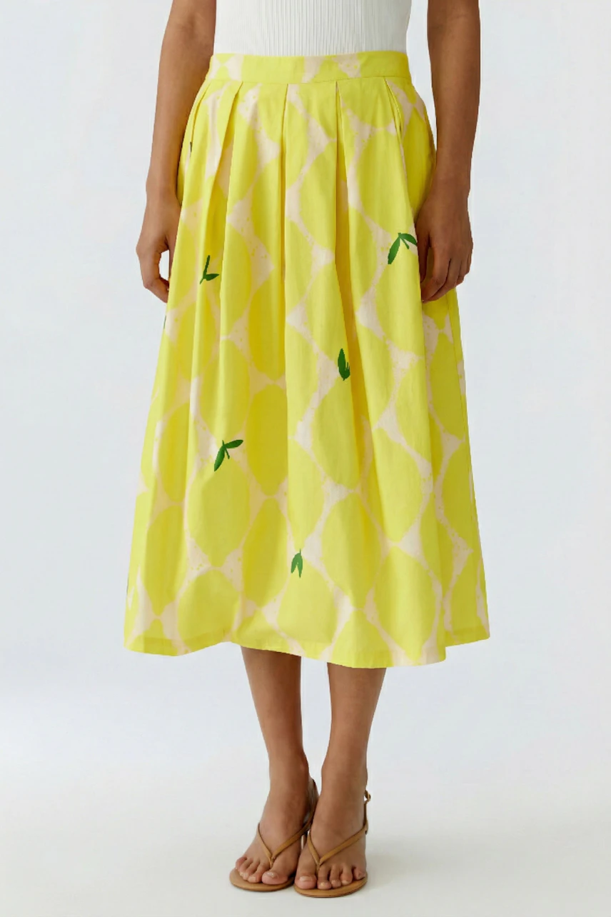 Yellow pleated skirt: Woman in a bright yellow skirt with subtle patterns and a white top.