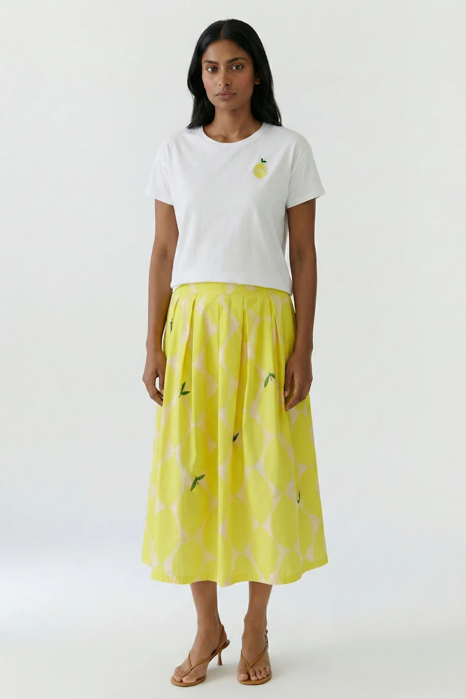 Bright yellow pleated skirt with geometric pattern, perfect for a vibrant and stylish look.