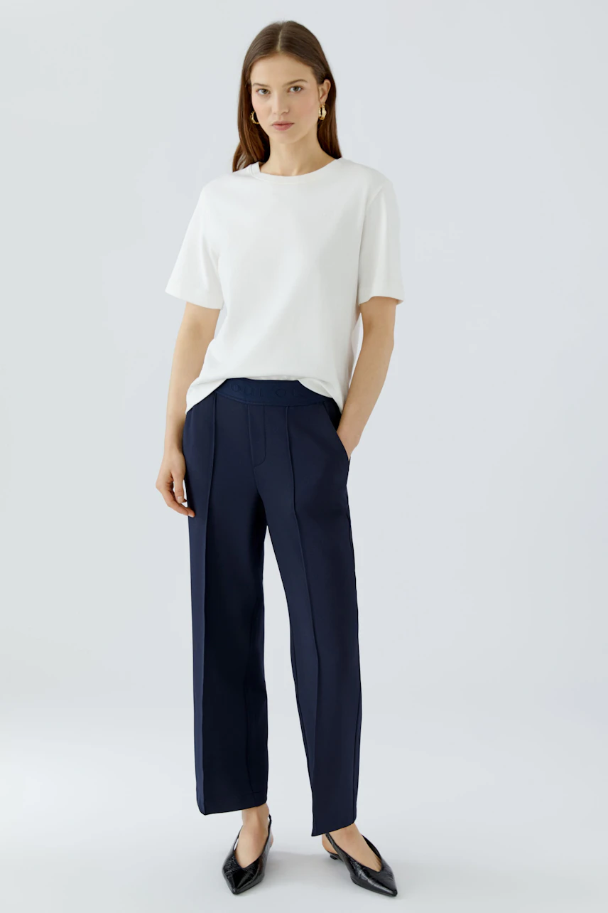 Chic culotte: Woman in navy culottes paired with a white shirt, showcasing a relaxed and modern style.