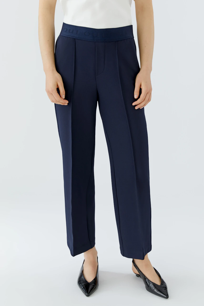 Modern culotte: Woman in navy wide-leg pants with a comfortable waistband, styled with a classic shirt.