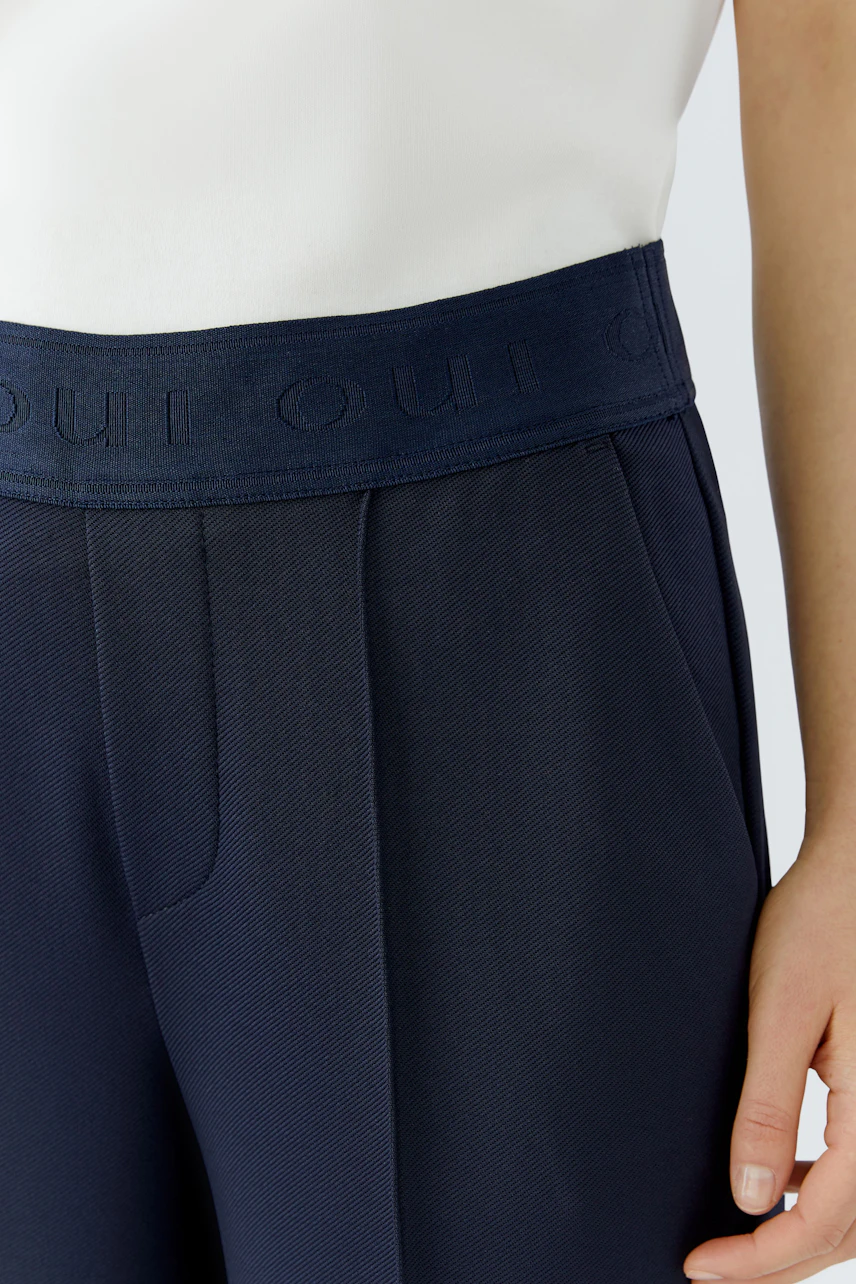 Modern culotte: Woman in navy culottes with a comfortable waistband, styled with a classic shirt.