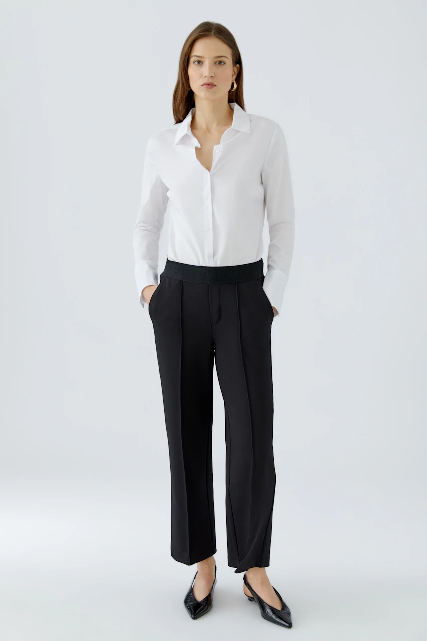 Modern culotte: Woman in black culottes paired with a white shirt, showcasing a relaxed style.