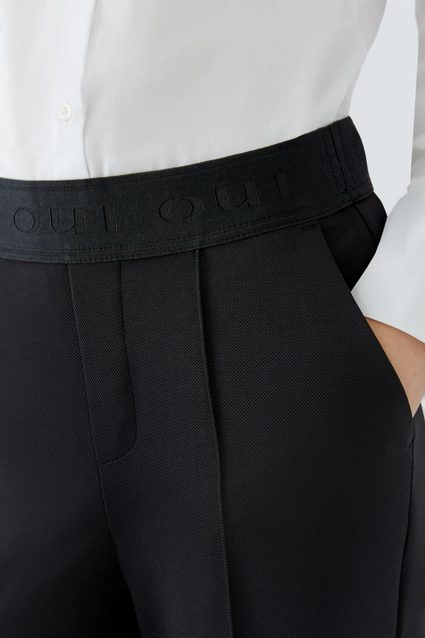 Modern culotte: Close-up of a woman wearing black culottes with a comfortable waistband.