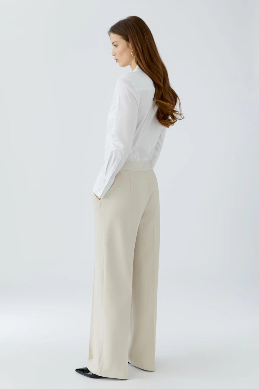 Casual women's trousers: A woman in light beige wide-leg trousers with a comfortable fit.