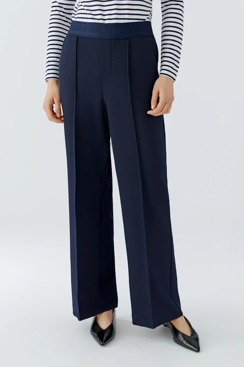 Stylish women's trousers: A woman in navy wide-leg pants with a comfortable waistband and pockets.