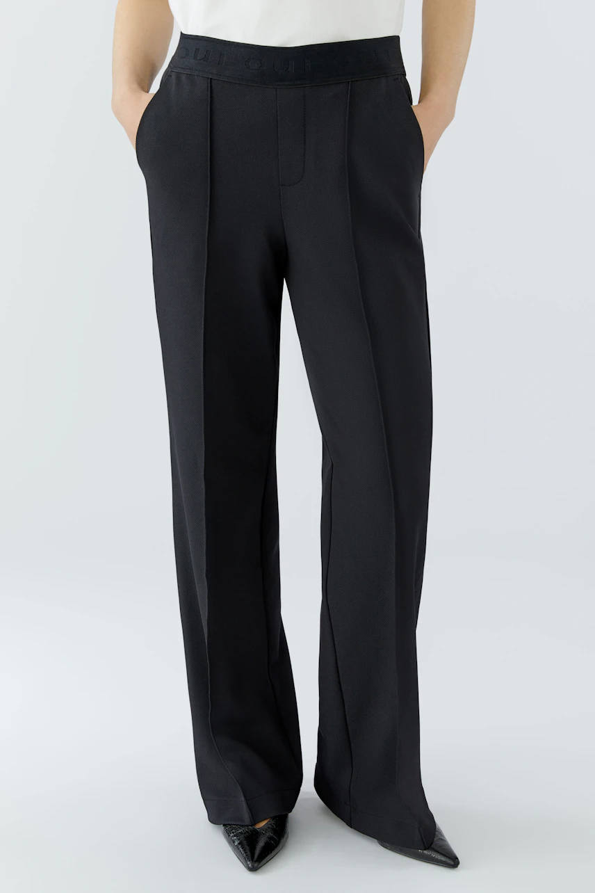 Comfortable women's trousers in black with a stylish waistband and practical pockets.
