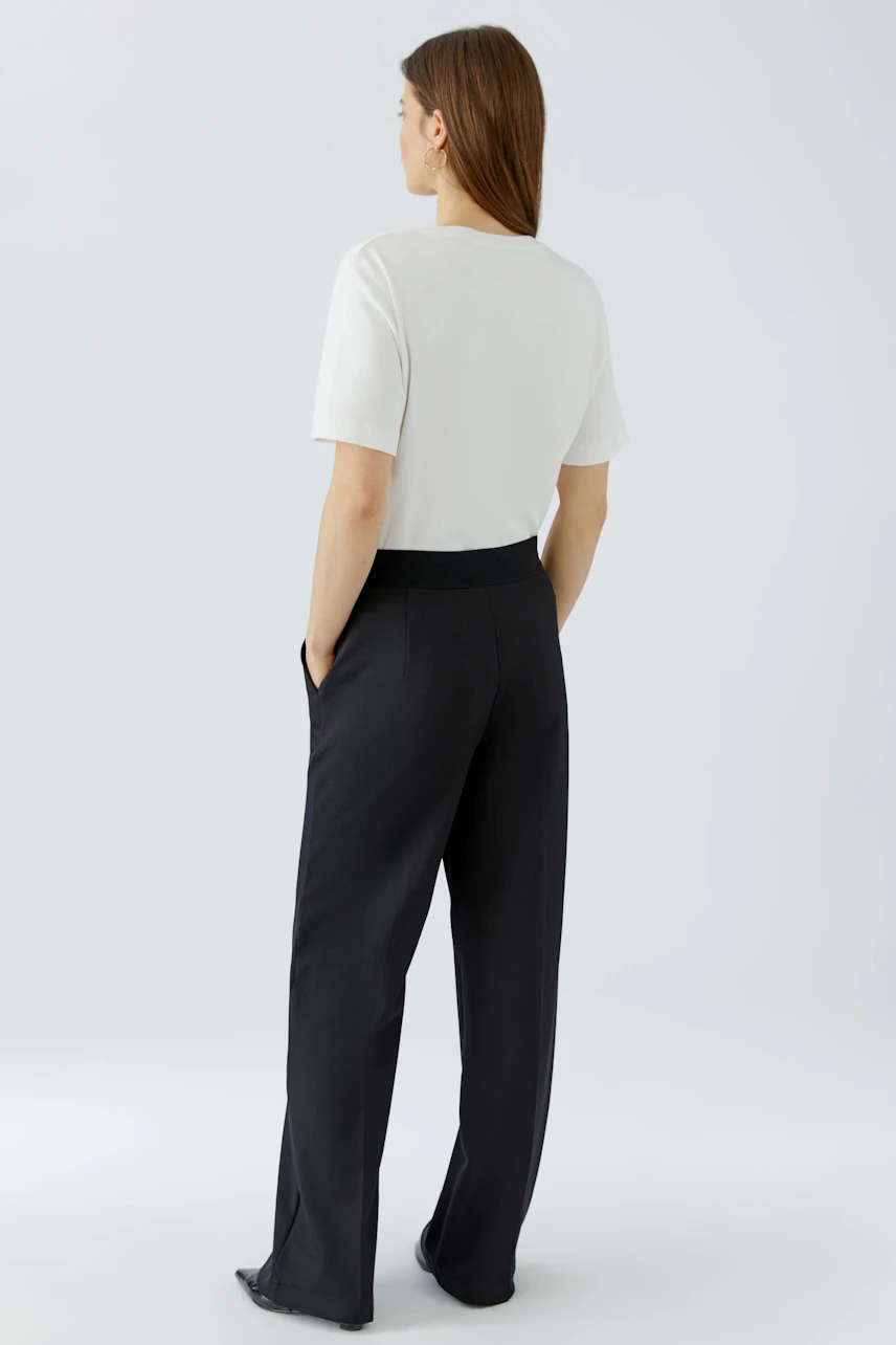Casual women's trousers: A woman in black wide-leg trousers with a comfortable fit and side pockets.