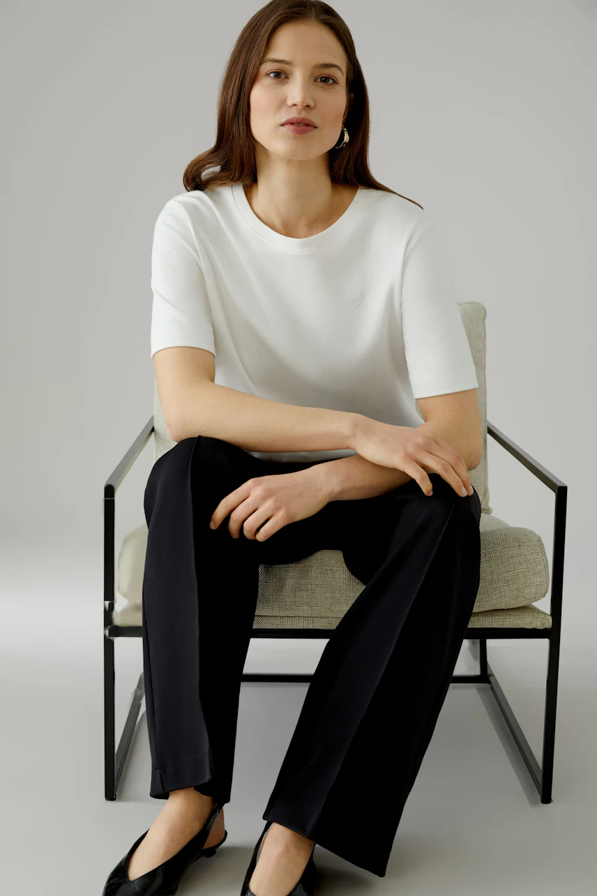 Casual women's trousers: A woman in black wide-leg trousers with a relaxed fit and a simple top.