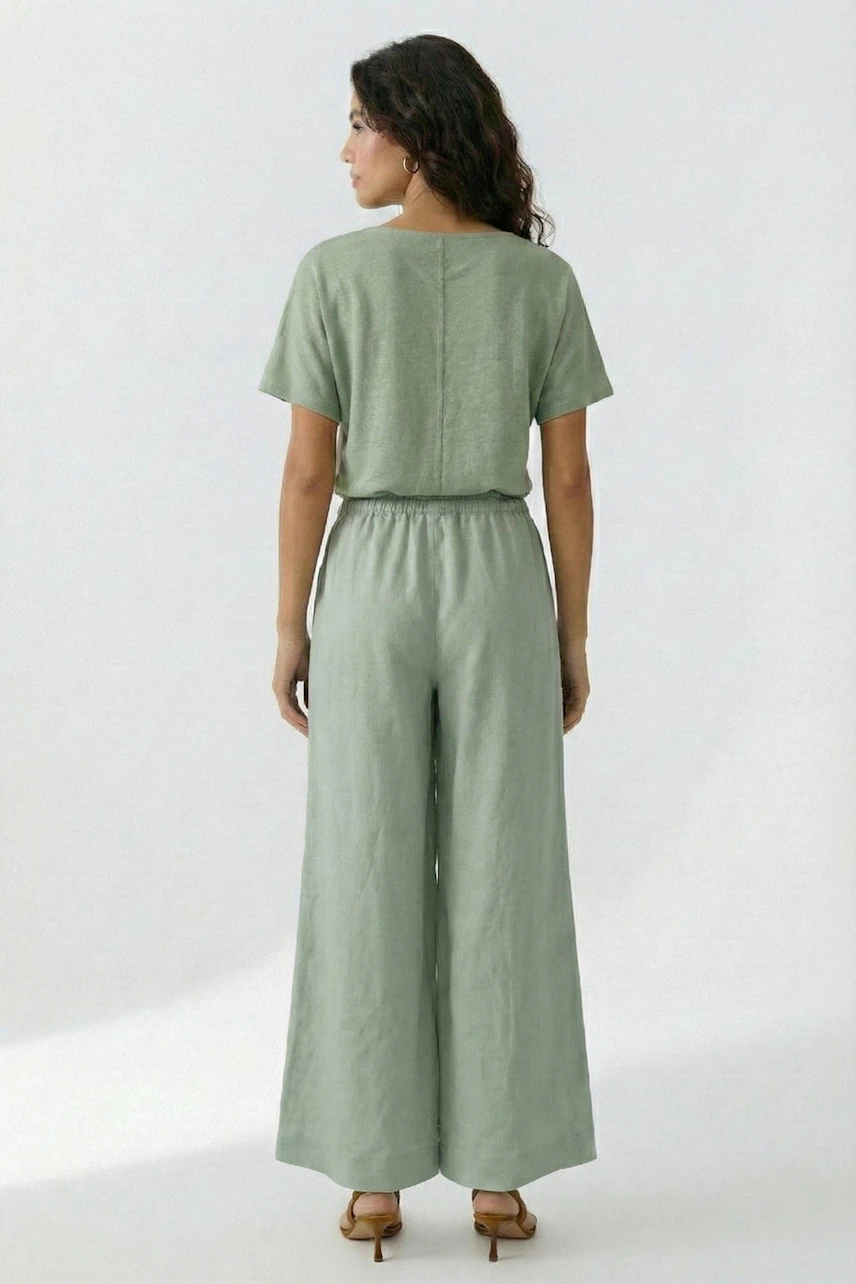 Woman in green Marlene pants and matching top, standing confidently. Wide-leg design offers relaxed fit.