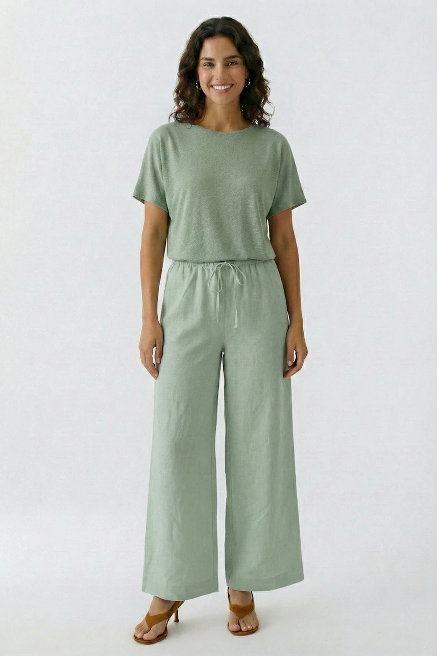Woman in relaxed Marlene pants and matching top, smiling confidently. Casual and comfortable style.
