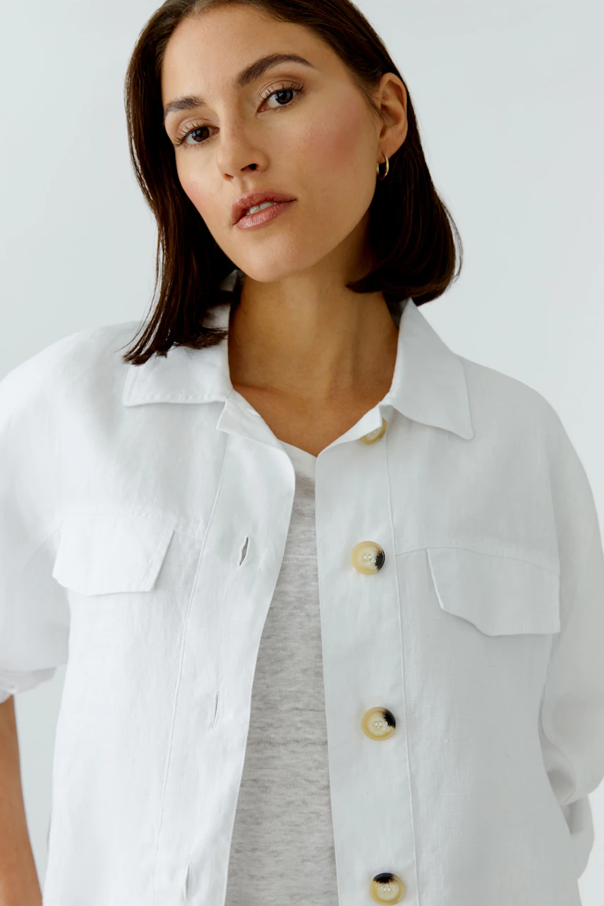 Lässiger Blouson: Frau im weißen Blouson mit großen Knöpfen und lockerer Passform.