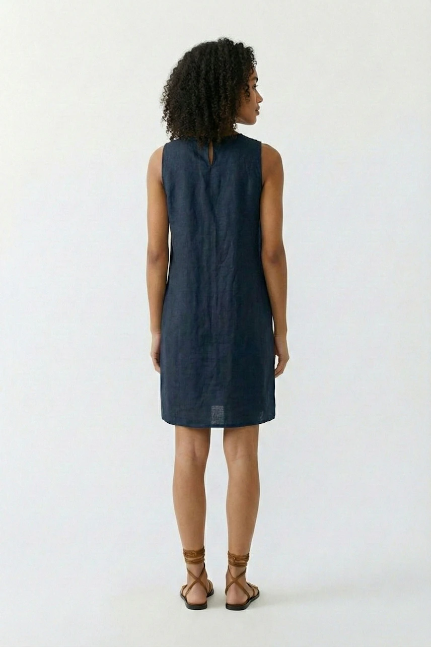 A-line dress: Woman in sleeveless navy dress, back view, with curly hair and brown sandals.