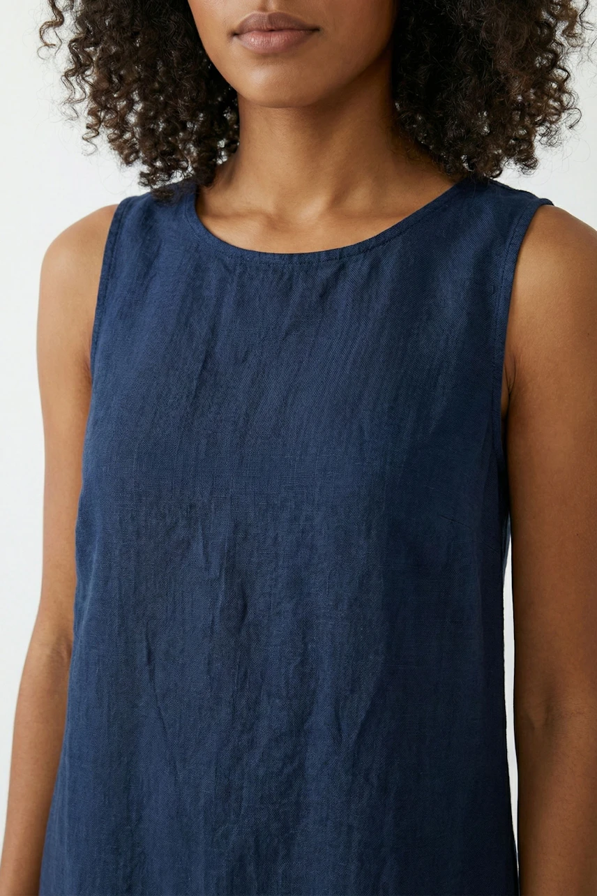 A-line dress: Woman in a sleeveless navy A-line dress, simple and stylish for everyday wear.