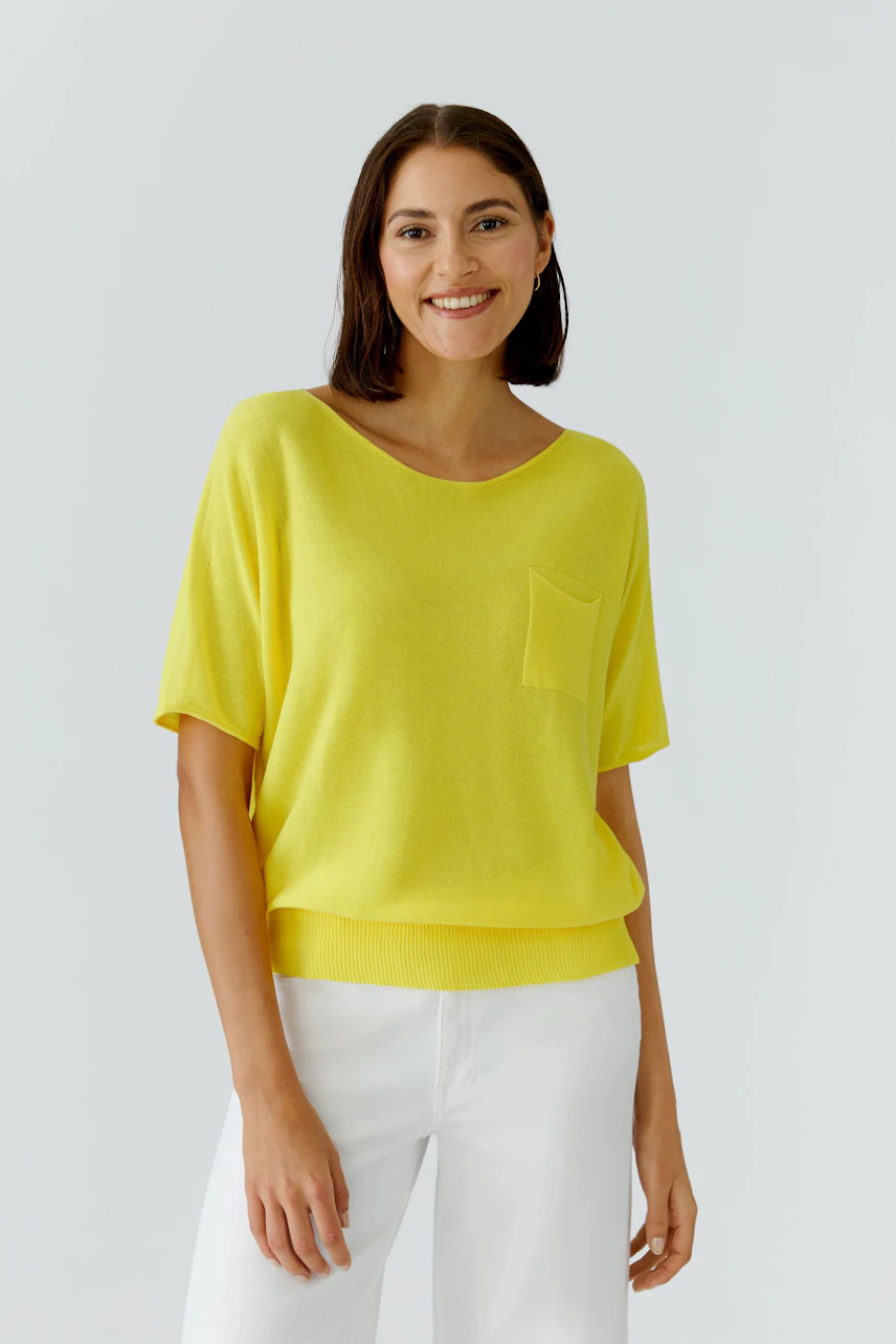 Casual women's pullover: Smiling woman in a bright yellow pullover with short sleeves and a chest pocket.