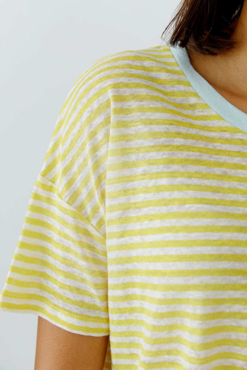 Gestreiftes Damen-T-Shirt: Frau trägt gelb-weiß gestreiftes T-Shirt mit hellblauem Kragen.
