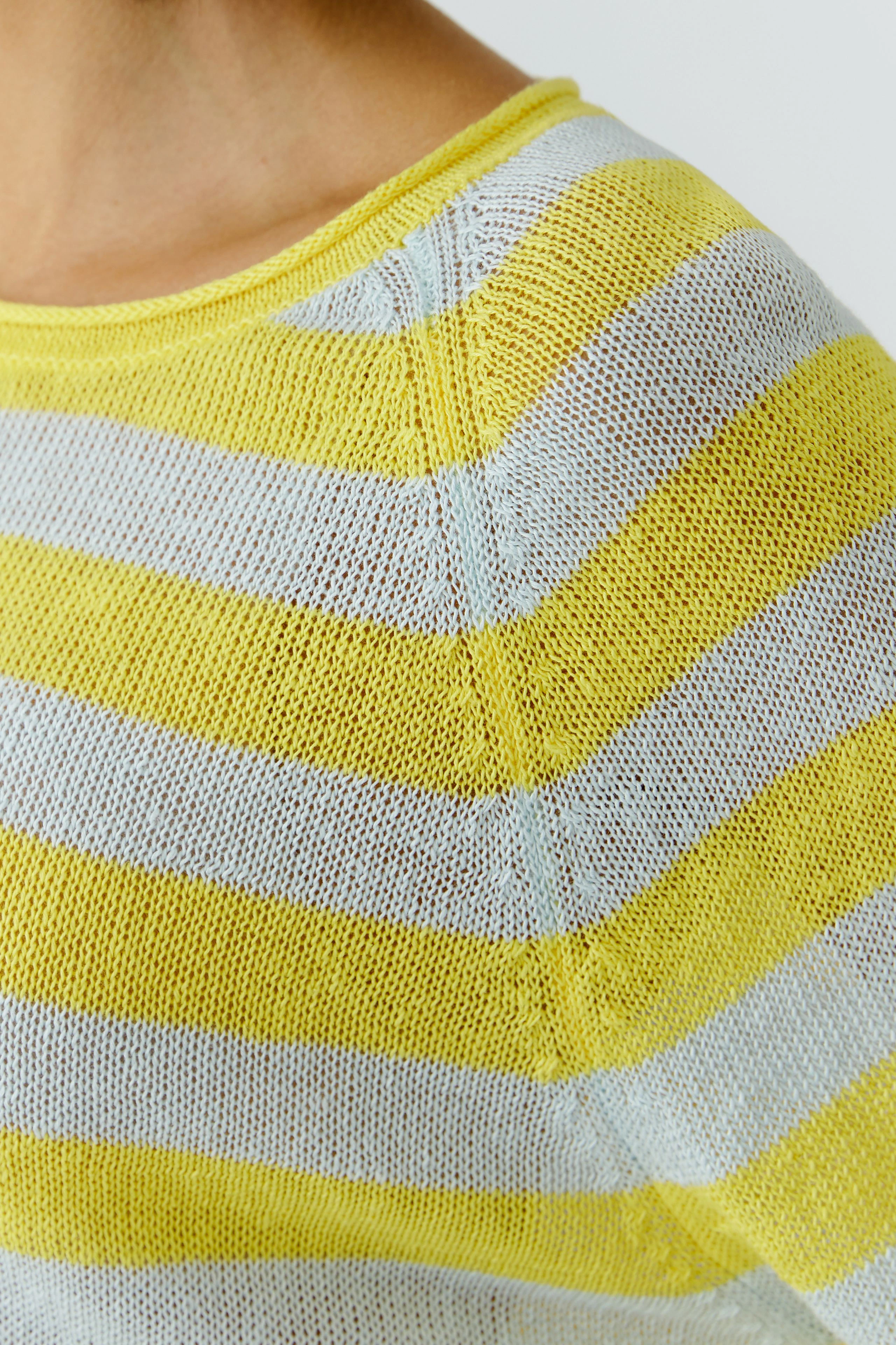 Gestreifter Damen-Pullover: Frau trägt gelb-weiß gestreiften Pullover aus leichtem Strickmaterial.