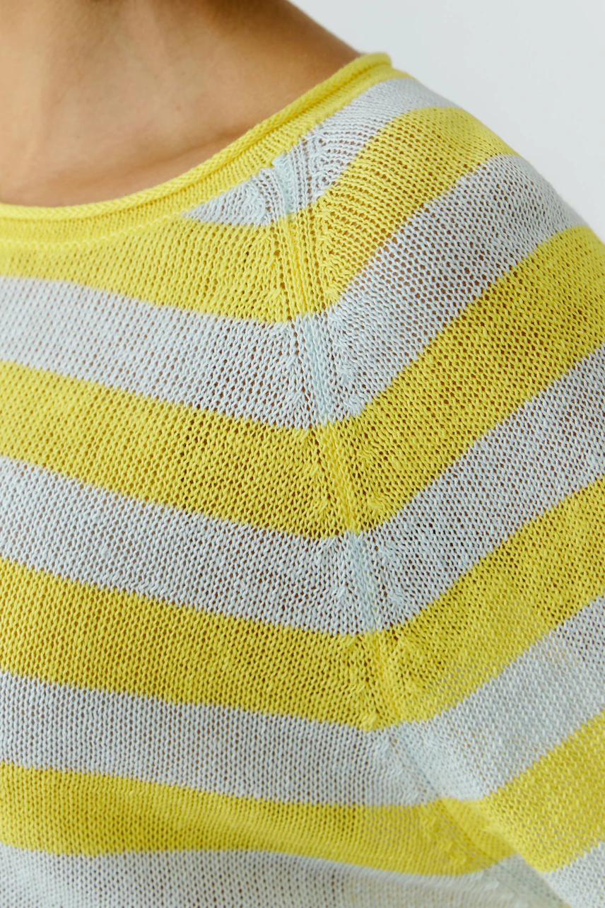 Gestreifter Damen-Pullover: Frau trägt gelb-weiß gestreiften Pullover aus leichtem Strickmaterial.