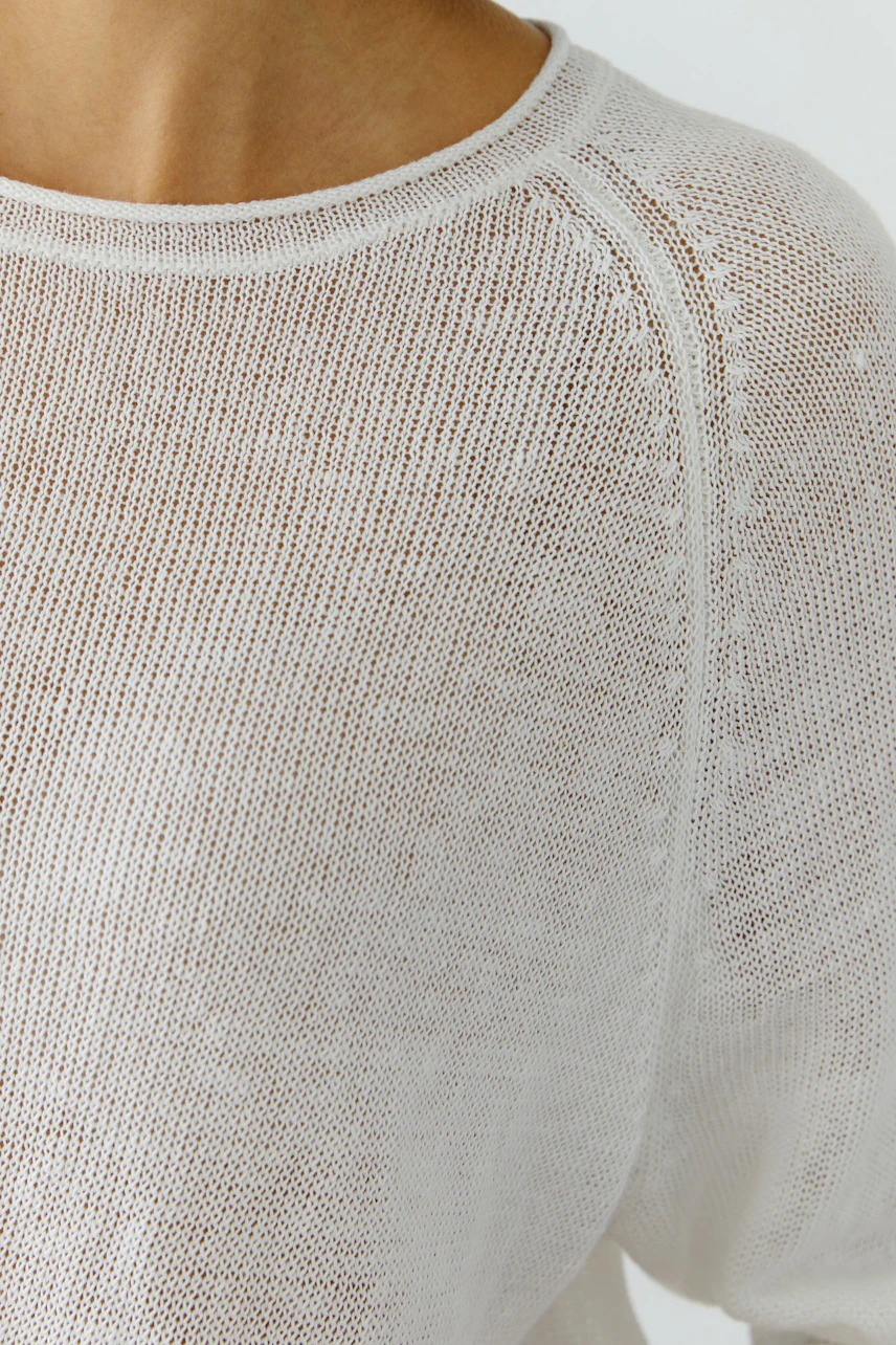 Weißer Damen-Pullover: Frau trägt lässigen, durchsichtigen Strickpullover mit Rundhalsausschnitt.