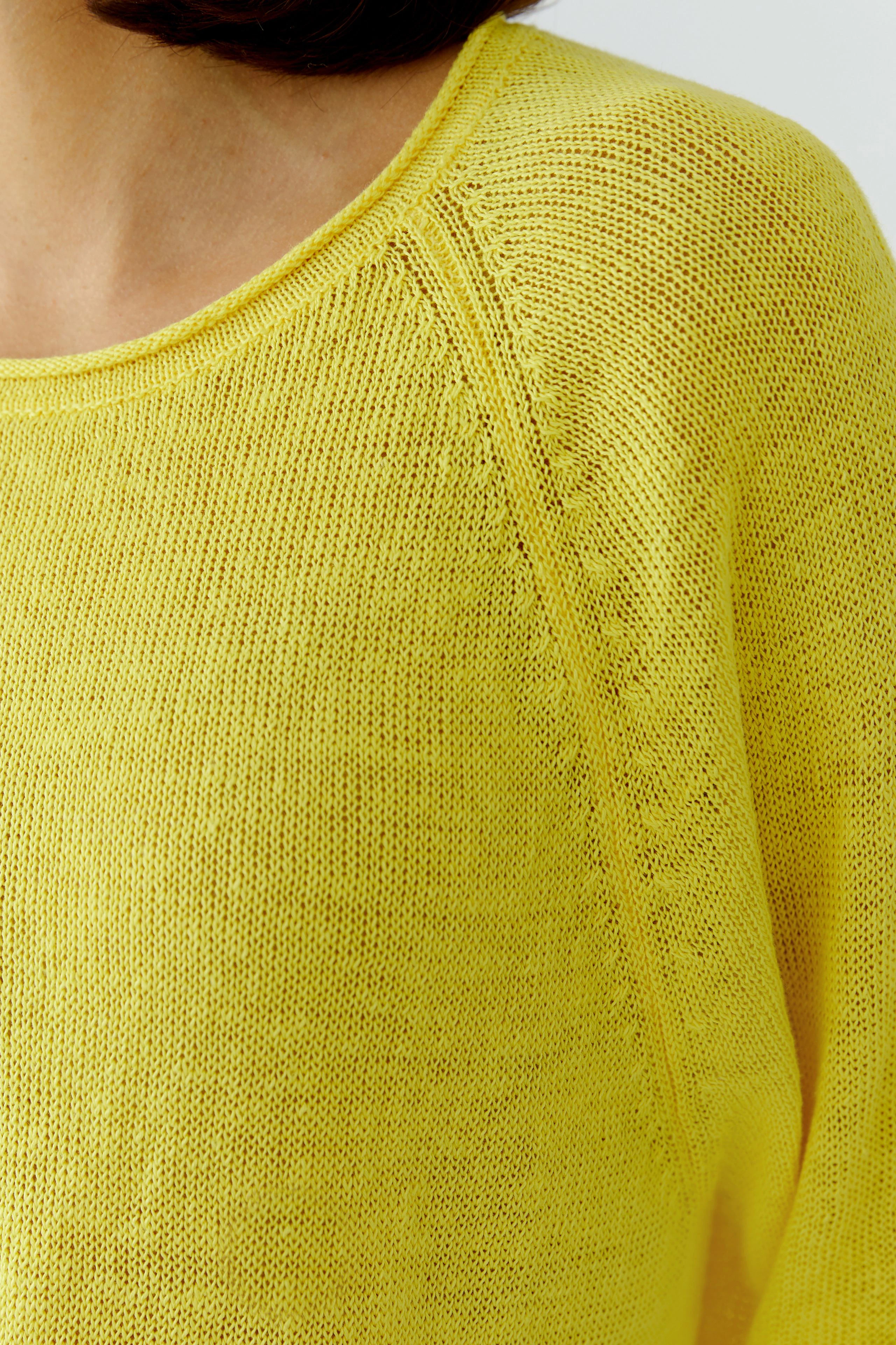 Bright yellow pullover: Woman in a casual knit pullover with a relaxed fit, showcasing vibrant color.