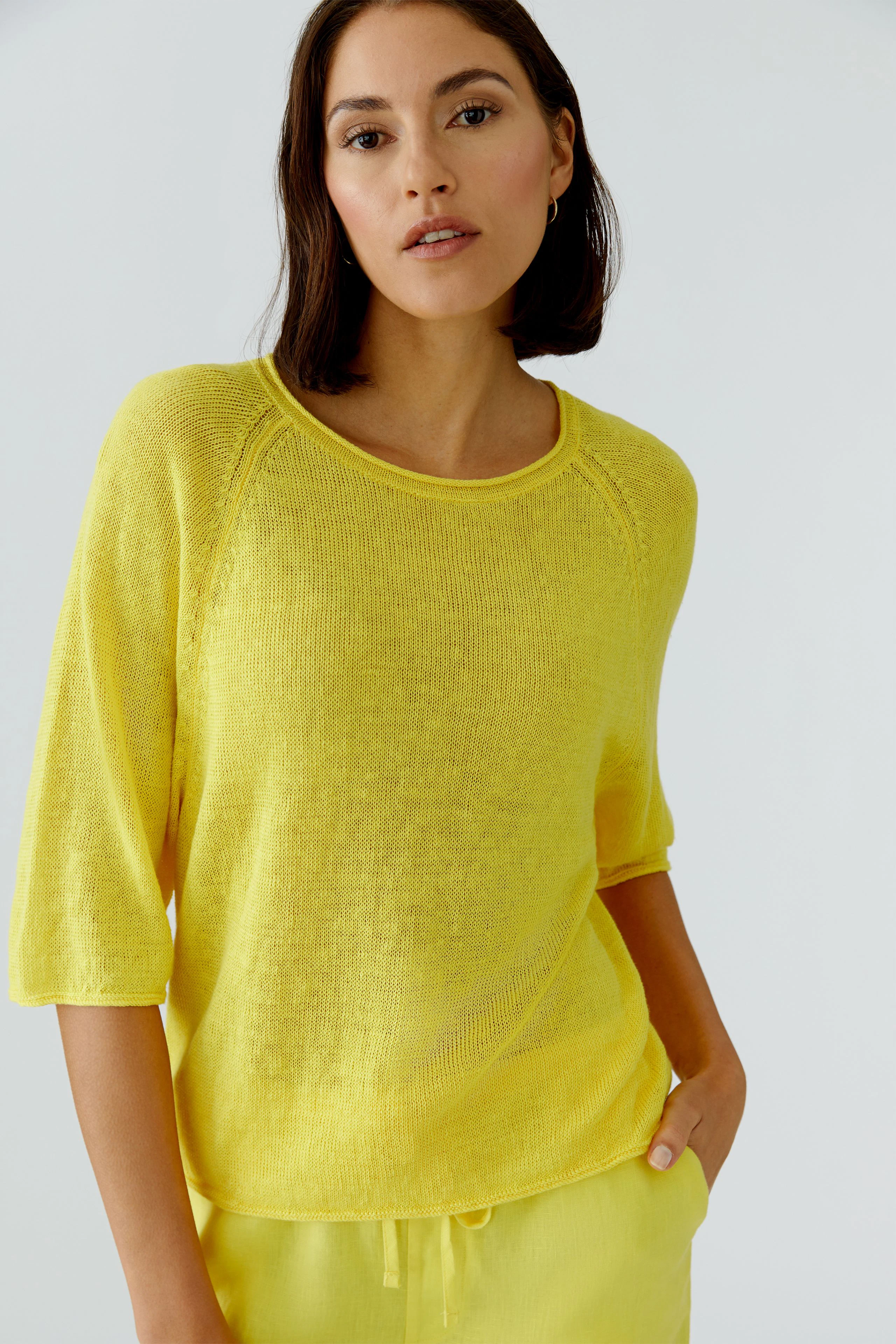 Casual women's pullover: Woman in a bright yellow pullover with relaxed fit and 3/4 sleeves.