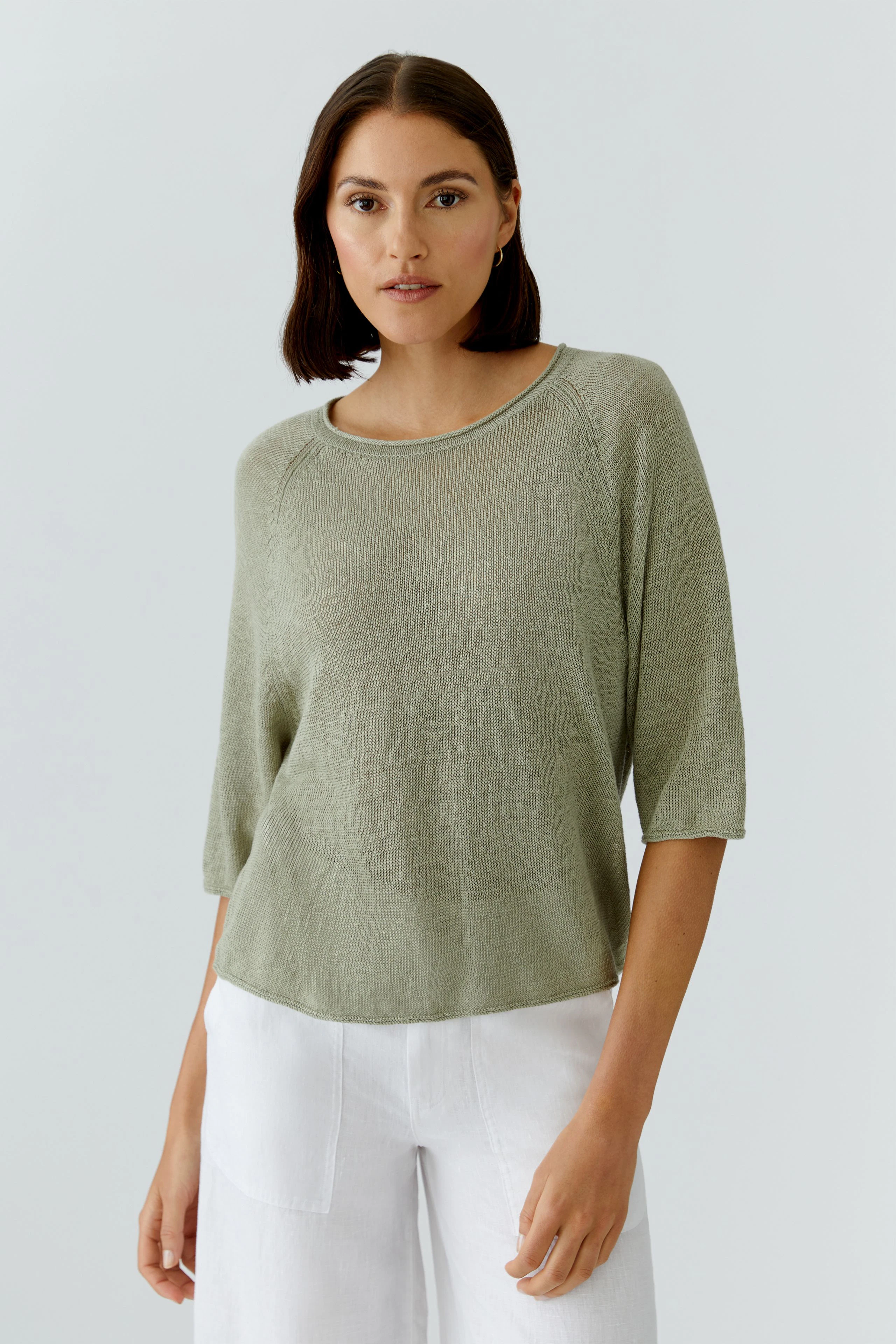 Casual women's pullover: Woman in light green pullover with 3/4 sleeves and relaxed fit.