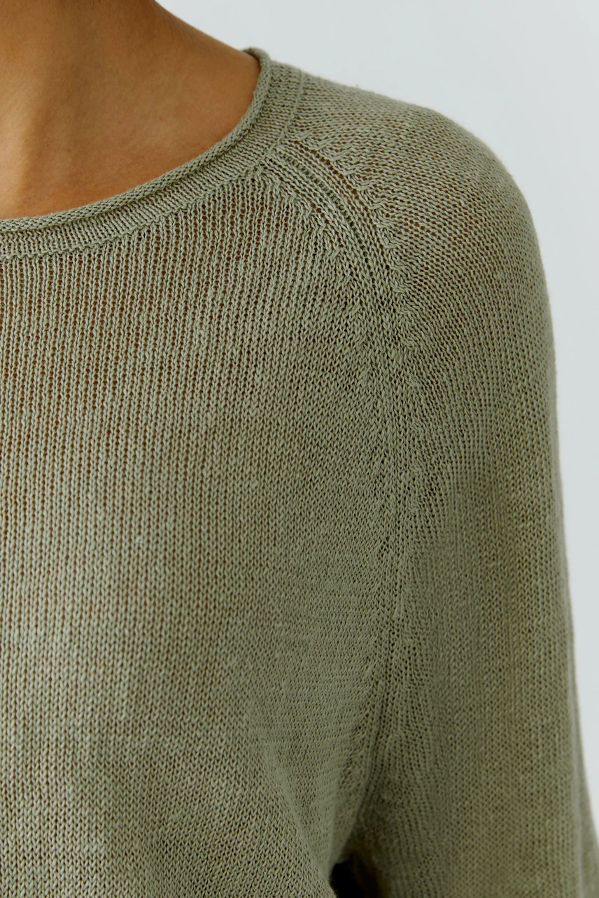 Lässiger Damen-Pullover: Frau im olivgrünen Strickpullover mit Rundhalsausschnitt, schlicht und modern.